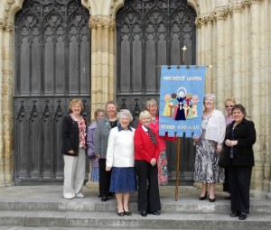 manx group with banner outside cathedral